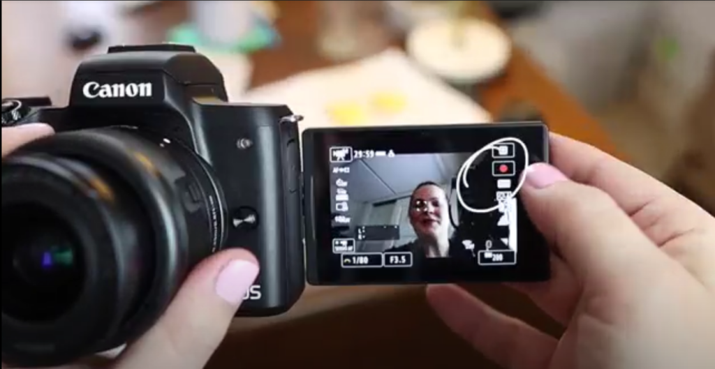 Meredith is showing the record button on the Canon m50 Mark ii.